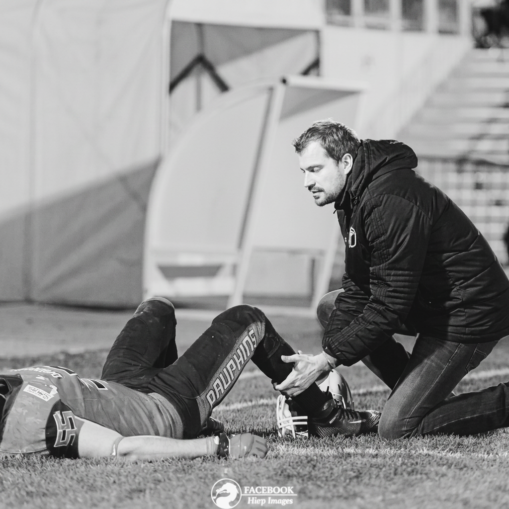 Jean Lienhardt prodiguant un soin à un sportif sur le terrain